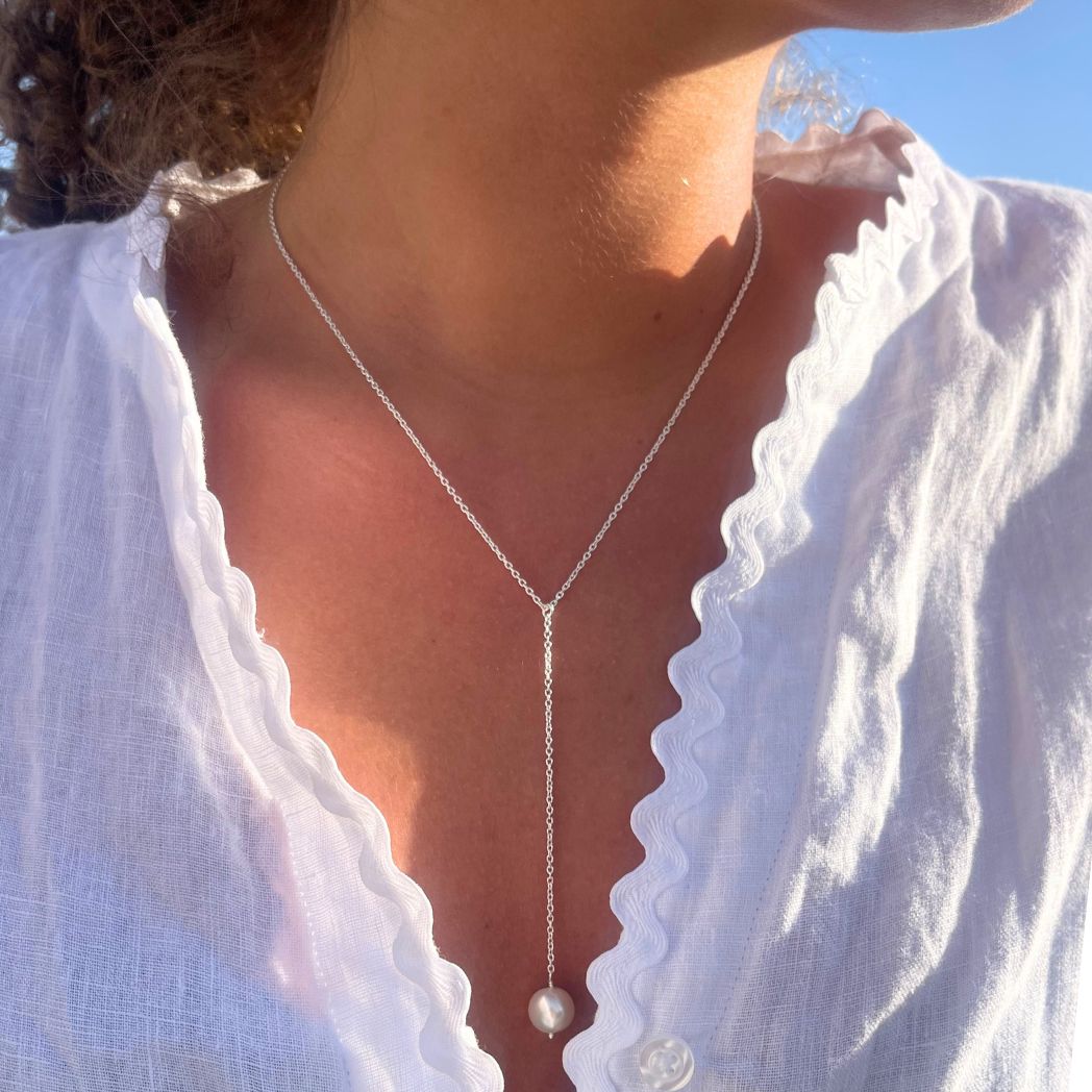 2 Pearly silverhalsband med en pärla på modell med lockigt hår och vit blus