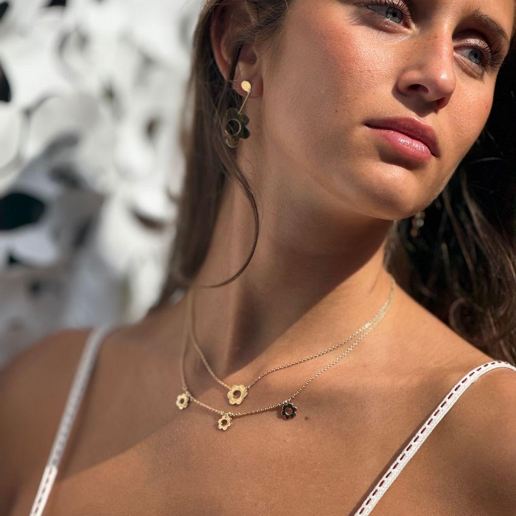 Halsband och örhänge i guld i formen av en Daisy (blomma)