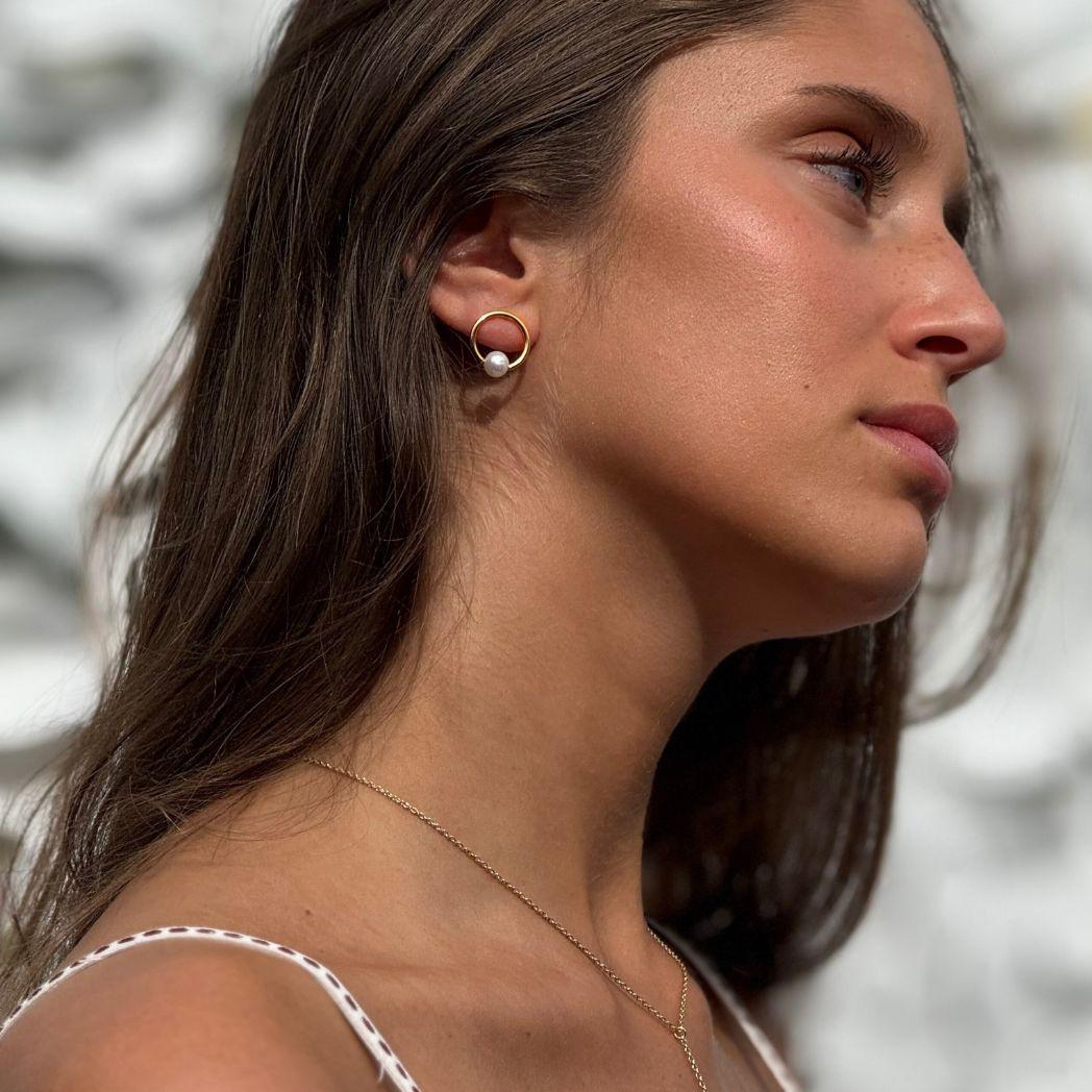 Pearly örhänge i guld medsötvattens pärla på modell