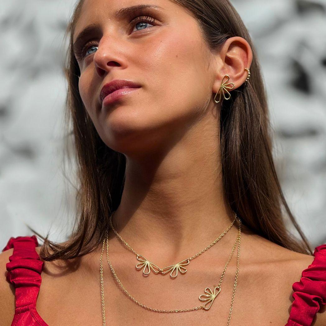 Guldörhänge i formen av en halv blomma utslagen och halsband i guld med samma form i blommorna